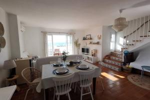 een woonkamer met een witte tafel en stoelen bij V. Lona: beautiful duplex with a stunning seaview in Es Mercadal