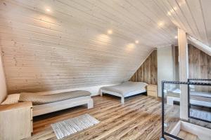 una camera con due letti su una parete in legno di Guest House a Lesko