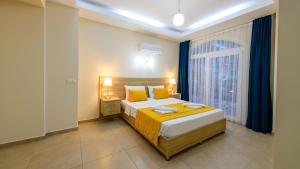a bedroom with a bed with yellow pillows and a window at Musa - 5 Bedroom Holiday Villa in Hisaronu in Fethiye +56 photos