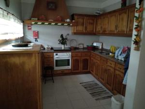 a kitchen with wooden cabinets and a stove top oven at Casa da Estivada, 313 in Vila do Conde