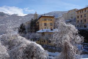 スカンノにあるAlbergo Centrale Scannoの雪に覆われた建物・木々群