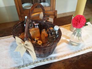 una cesta en una mesa con un jarrón con una flor en Agriturismo Il Casalino en Pienza