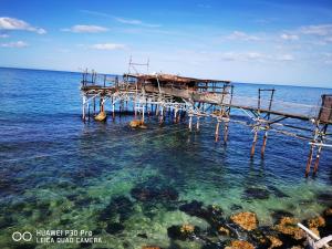een houten pier in de oceaan met water bij Casa vacanze da Nonna Rosa in Ortona