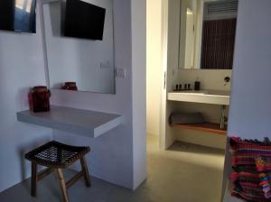 a bathroom with a counter and a sink and a stool at Wabi Luxury Suites & Maisonettes Ios in Ios Chora +70 photos