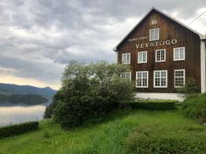 LøkenExperience Jotunheimen from Vevstogo - sauna with a view and eco living in an old school building的一座大型木结构建筑,位于一座小山上,