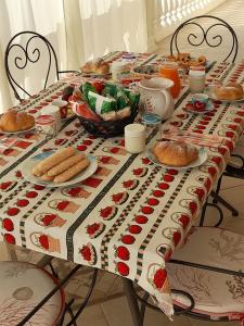 a table with a table cloth with food on it at B&B La Collina in Posada