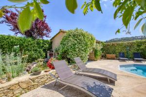 un patio con 2 sillas de césped y una piscina en Le Mas de la Noria, en La Cadière-dʼAzur