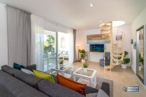 una sala de estar con un sofá gris y algunas plantas en DUPLEX in Nueva Andalucia, Golfers Paradise, en Marbella