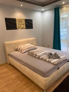 a bed in a bedroom with blue curtains at Gabrielle2 apartman in Debrecen