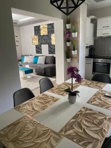 a dining room with a table with purple flowers on it at Gabrielle2 apartman in Debrecen