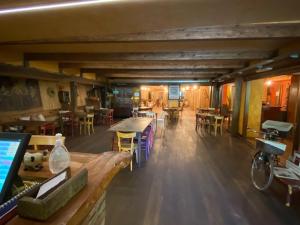 ein großes Zimmer mit Tischen und Stühlen in einem Gebäude in der Unterkunft Hotel Le Clou in Arvier