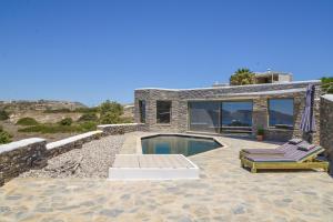a house with a swimming pool and two lounge chairs at Valeria's House in Adamantas