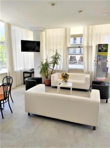 里米尼的住宿－馬德里酒店，客厅配有白色的沙发和桌子