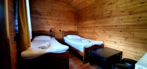 a room with two beds in a wooden cabin at Oda Kazbegi in Stepantsminda
