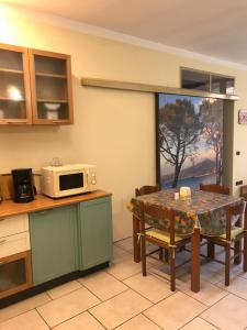 kuchnia ze stołem i kuchenką mikrofalową w obiekcie KINDLY ROBERTA centro storico Peschiera,lago relax w mieście Peschiera del Garda +14 zdjęć