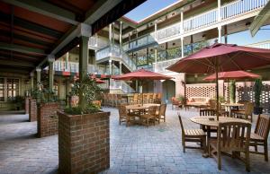 an outdoor patio with tables and chairs and umbrellas at Willow Lodge in Myrtle Beach