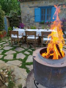 a fire pit in a yard with tables and chairs at Adatepe Otel in Adatepe