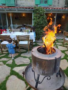 a little girl standing next to a fire pit at Adatepe Otel in Adatepe