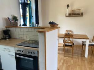 a kitchen with a stove and a wooden table at Ferienwohnung am Stadtgraben in Wilsdruff