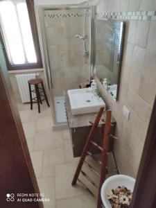 ein Bad mit einem Waschbecken, einer Dusche und einem Spiegel in der Unterkunft Truly Home Short Lets in Locorotondo
