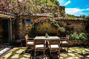 a table and chairs in a yard with flowers at Adatepe Otel in Adatepe +7 photos