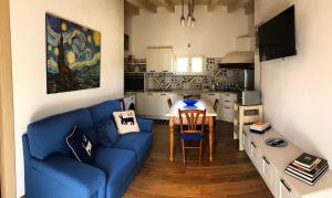 salon z niebieską kanapą i stołem w obiekcie Casa vacanza centro Sardegna w mieście Sorgono