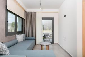 a living room with a blue couch and a table at Marajo Suites in Skala Potamias