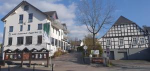 une rue dans une ville avec un bâtiment blanc dans l'établissement Hotel Bigger Hof - Wirtshaus Platzhirsch am Jahnplatz, à Olsberg