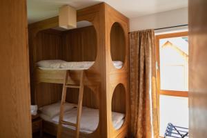 Pokój z łóżkiem piętrowym z 2 łóżkami piętrowymi i oknem w obiekcie Apartments Vila Jelka w Bohinju