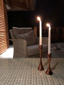 two candles sitting on a table with a couch at Apartments Vila Jelka in Bohinj