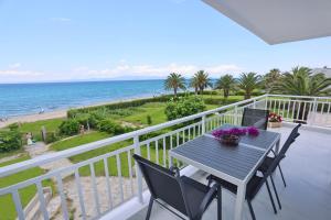 balcón con mesa, sillas y vistas al océano en Beach Front Casa Elena, en Chaniotis