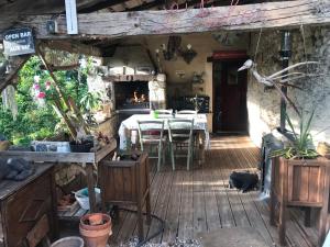 une terrasse avec une table et des chaises dans une maison dans l'établissement Le Peyrail, à Les Lèves-et-Thoumeyragues