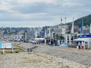 eine Stadt mit Gebäuden und Menschen, die auf einer Straße gehen in der Unterkunft Vivez Les 4 chemins - Plage - Quartier Saint Vincent in Le Havre