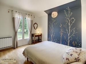 1 dormitorio con 1 cama grande y pared azul en Maison Lac et Montagne, en Barbazan
