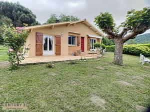 una pequeña casa con un árbol en el patio en Maison Lac et Montagne, en Barbazan