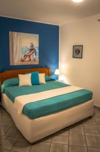 - une chambre avec un grand lit orné d'une peinture murale dans l'établissement Alcantara Natura Country House, à Graniti