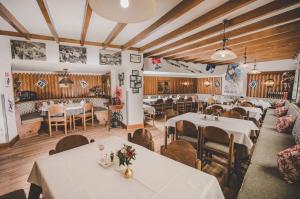 a restaurant with white tables and chairs and wooden ceilings at Kurhotel & Hotel Mozart in Bad Gastein