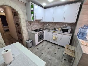 een keuken met witte kasten en een aanrecht bij 2-х кім.квартира в центрі Берегова in Berehove