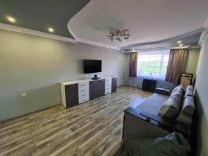 sala de estar con sofá y TV de pantalla plana en 2-х кім.квартира в центрі Берегова, en Beregovo