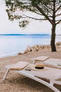 a picnic table with a hat and sunglasses on a beach at Hotel Miramare in Crikvenica