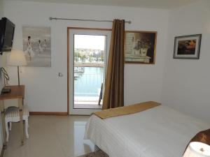 a bedroom with a bed and a sliding glass door at Marina-M in Lagos +44 photos