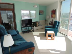 a living room with blue couches and a tv at Marina-M in Lagos