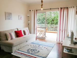 uma sala de estar com um sofá e uma porta de vidro deslizante em Refugio Madeira no Caniço