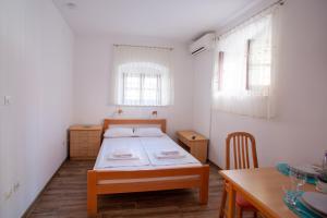 a small bedroom with a bed and a table at Arcobaleno Apartments in Piran