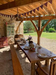 une table en bois sous une pergola en bois dans l'établissement Coutillard, à Parisot