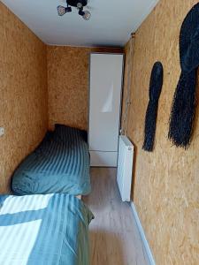 um pequeno quarto com uma cama e uma porta em Chalet 't Veluws stulpje "GENIET, ONTSPAN EN DROOM EVEN LEKKER WEG!" em Putten