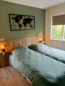 um quarto com duas camas e uma foto na parede em Chalet 't Veluws stulpje "GENIET, ONTSPAN EN DROOM EVEN LEKKER WEG!" em Putten