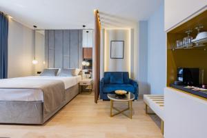 a hotel room with a bed and a blue chair at Caldo Luxury Rooms in Split