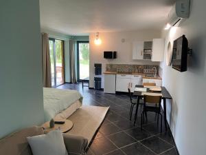 ein Wohnzimmer mit einem Bett und eine Küche in der Unterkunft Superbe studio privée au calme avec piscine et spa in Sailly-lès-Lannoy