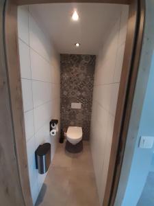 uma pequena casa de banho com um WC e uma parede de pedra em Bee Tree Appartement em Vielsalm